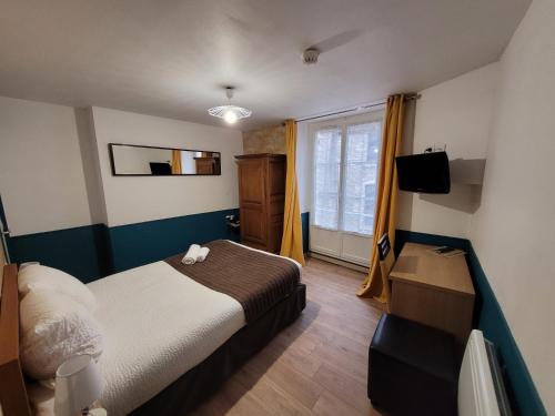 une chambre avec un lit sur lequel est assis un chat dans l'établissement Hôtel de L'Ecu, à Montbard