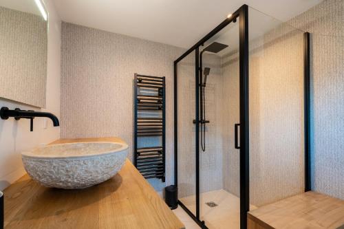 La salle de bains est pourvue d'un grand lavabo en pierre et d'une douche. dans l'établissement La sublime villa du moulin avec vue mer exceptionnelle !, à Mèze