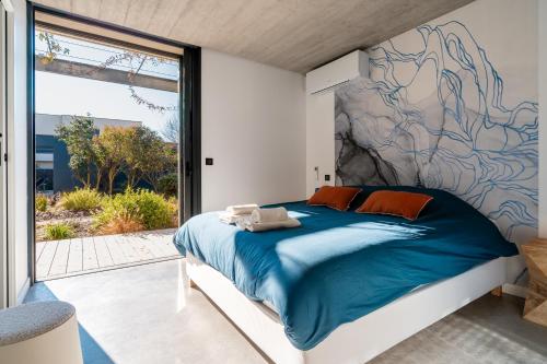 une chambre avec un grand lit avec une grande fenêtre dans l'établissement La sublime villa du moulin avec vue mer exceptionnelle !, à Mèze