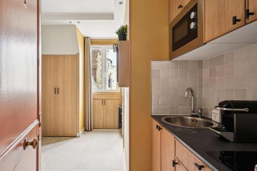 une cuisine avec un évier et un plan de travail dans l'établissement Charming studio - 1P - Porte-Dauphine-Trocadero, à Paris