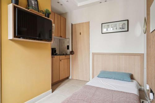 Cette petite chambre comprend un lit et une télévision à écran plat. dans l'établissement Charming studio - 1P - Porte-Dauphine-Trocadero, à Paris