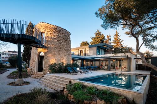 une maison avec une piscine et un bâtiment dans l'établissement La sublime villa du moulin avec vue mer exceptionnelle !, à Mèze