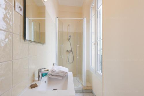 une salle de bain blanche avec une douche et un lavabo dans l'établissement Carrousel stud, à Cannes