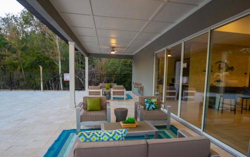 an outdoor patio with couches and tables and chairs at Beautiful 4BD home Themed Pool and Grill 4417 in Kissimmee