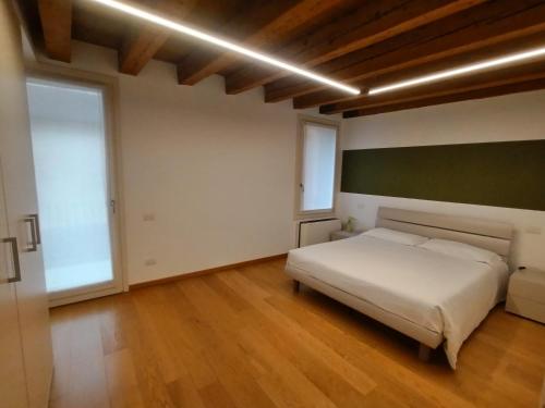 a bedroom with a white bed and a large window at Residenza Della Samaritana in Verona