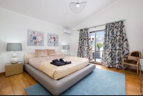 a bedroom with a large bed with a blue rug at English house in Ponta Delgada