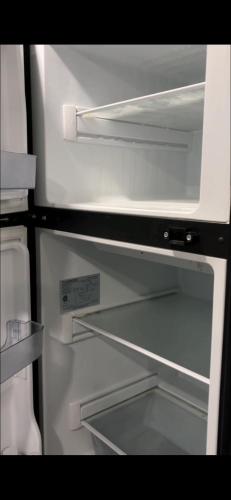 a white refrigerator with its door open with its door at Kyan caravan in Muhya