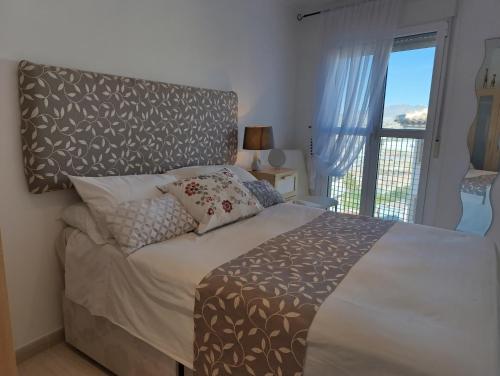 a bedroom with a bed with a large window at Apartamento Mare Nostrum in Puerto de Mazarrón