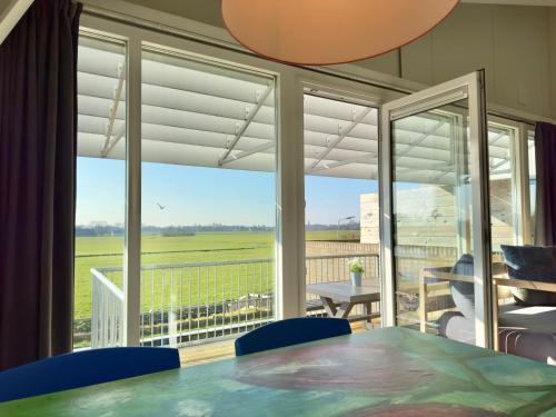 a room with a table and chairs and a large window at Appartementen Casa del Lago in Lisse