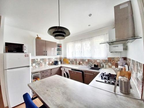 une cuisine avec un réfrigérateur blanc et un plan de travail dans l'établissement T3-Base Nature-Plages-Clim-WIFI, à Fréjus