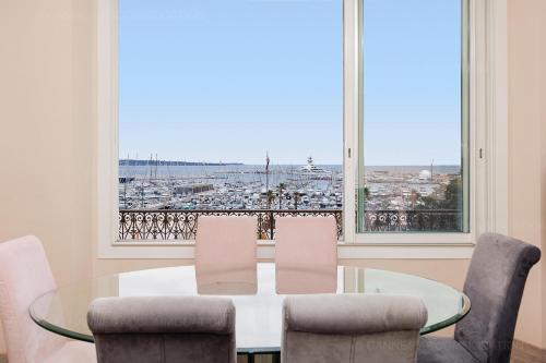 une salle à manger avec une table et des chaises et une grande fenêtre dans l'établissement Carrousel 4, à Cannes