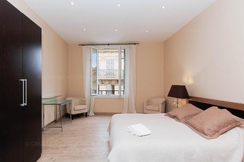 une chambre avec un lit, un bureau et une fenêtre dans l'établissement Carrousel 4, à Cannes