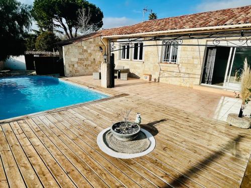 une terrasse en bois à côté d'une piscine dans l'établissement Villa 7 pers entre Cannes et St Tropez avec piscine au calme, à Puget-sur Argens