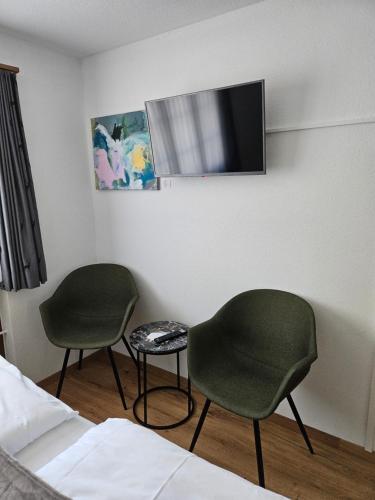 a room with two chairs and a tv on the wall at Gasthof Tenne in Lenk