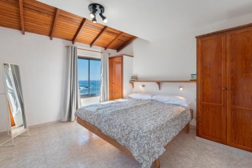 Un dormitorio con una cama y una ventana grande en La Bayana Apartments - 8, en Puerto Naos