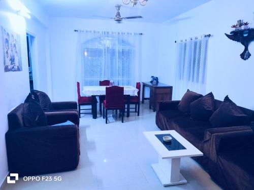 a living room with couches and a table and a dining room at ColvaPearl Deluxe Luxury Villa and Apartments Wi-Fi in Colva