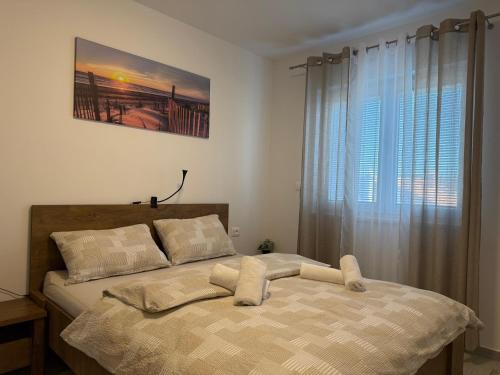 a bed in a bedroom with a large window at Apartman Panda - free parking in Pula