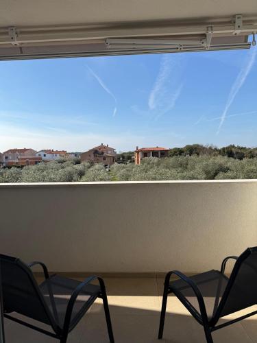 two chairs sitting in front of a large window at Apartman Panda - free parking in Pula