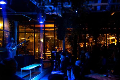 a crowd of people sitting in a bar at night at Combo Milano in Milan
