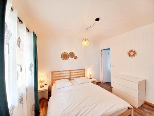 - une chambre avec un lit blanc et 2 tables de chevet dans l'établissement T3-Base Nature-Plages-Clim-WIFI, à Fréjus