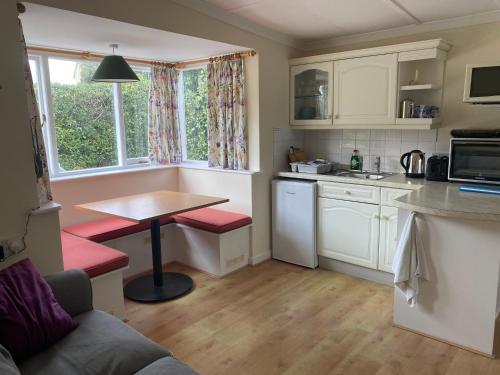 a small kitchen with a table and a counter top at The Cottage, ground floor property near the beach in Seaview