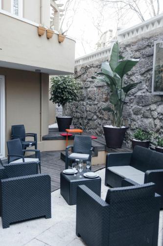 a patio with chairs and tables and a stone wall at Ark of Aqua Flat in Porto