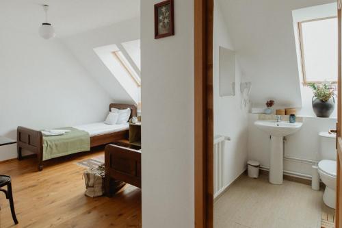 a bathroom with a bed and a sink in a room at Vass Panzio in Zălan