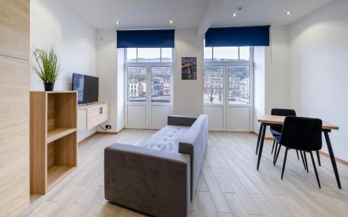 a living room with a couch and a table at NOMAD APARTMENTS - Côté Meuse in Dinant