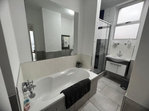 Un baño blanco con bañera y lavabo. en Sunrise Cview, en Ballito