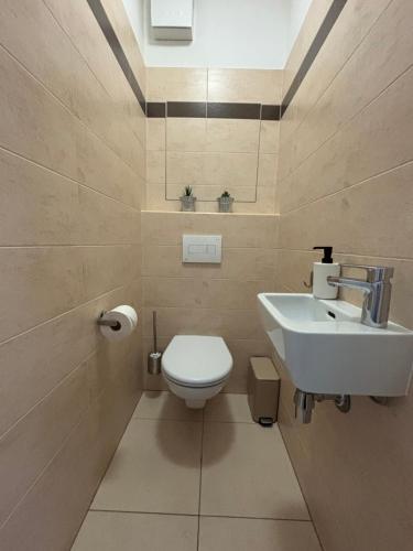 a bathroom with a white toilet and a sink at Self check in with parking included in Bratislava