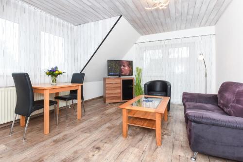 salon z kanapą i stołem w obiekcie Seehund 1 w mieście Esens
