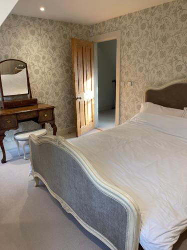 a bedroom with a bed and a dresser and a mirror at Everdon Hill House - B&B in Great Everdon