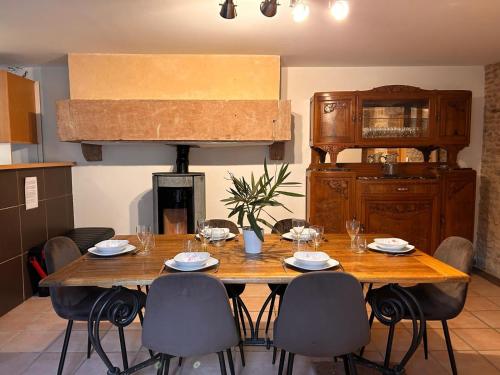 - une table à manger avec des chaises, une table en bois et une table dans l'établissement Le Coup de Coeur Terrasse Calme, à Sancé