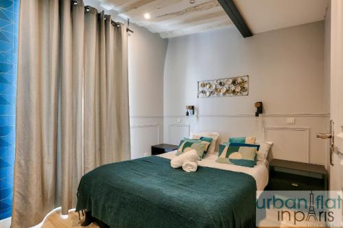 une chambre avec un lit avec une couverture verte dans l'établissement Urban Flat 44 - Chenier, à Paris
