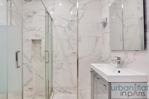 une salle de bain blanche avec une douche et un lavabo dans l'établissement Urban Flat 44 - Chenier, à Paris