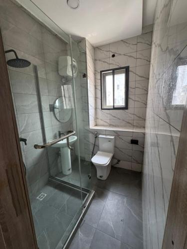Un baño con inodoro y ducha de cristal. en 2 BR Luxury Apartment in Camberwall Advantage II, en Lekki