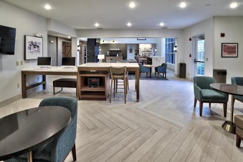 an open living room with chairs and a table at Staybridge Suites - Albuquerque Airport by IHG in Albuquerque