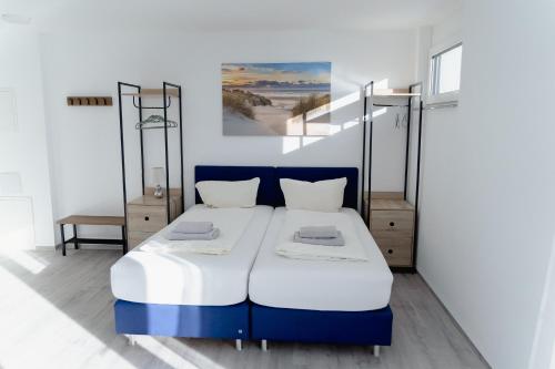 a blue and white bed in a room with stairs at GrenzApartments in Bietingen