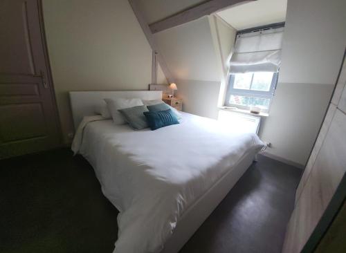 un lit blanc dans une chambre avec une fenêtre dans l'établissement Villa de charme près de Sarlat Périgord, à Anglars-Nozac