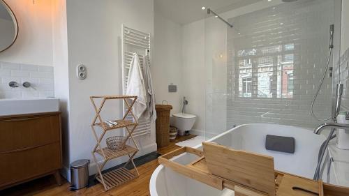 une salle de bain avec une baignoire, un lavabo et des toilettes dans l'établissement Maison la Madeleine Romarin !, à Lille