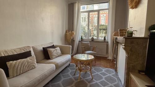 un salon avec un canapé et une table dans l'établissement Maison la Madeleine Romarin !, à Lille