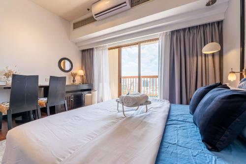 a bedroom with a large bed with a desk and a table at Resort Suites at Pyramid Tower by GL Staycation in Petaling Jaya