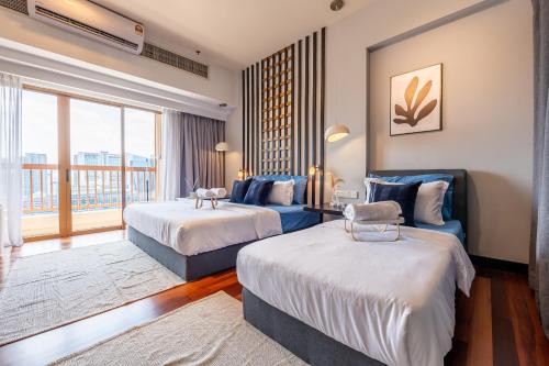 a hotel room with two beds and a balcony at Resort Suites at Pyramid Tower by GL Staycation in Petaling Jaya
