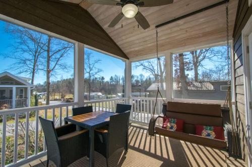eine abgeschirmte Veranda mit Tisch und Stühlen und einem Deckenventilator in der Unterkunft Cozy 1BR Tiny Home with Pool Access and Free Tix in Flat Rock