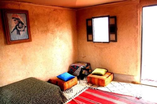 a room with two ottomans and two chairs in a room at Ngayan Camp in Marrakech