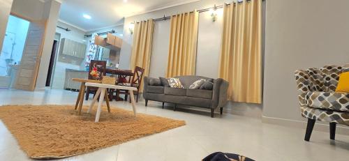 un soggiorno con un divano e un tavolo di Mwerwa's Loft a Kampala