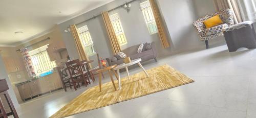 un soggiorno con tavolo e sedie in legno di Mwerwa's Loft a Kampala