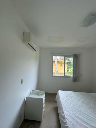 una stanza bianca con un letto e una finestra di Casa Villa Firenze a Mata de Sao Joao