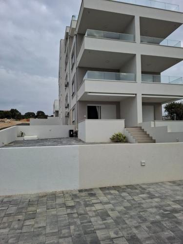 a large white building with stairs in front of it at Sunshine Apartment Complex with a Pool by the Beach - Mandre, Pag in Mandre