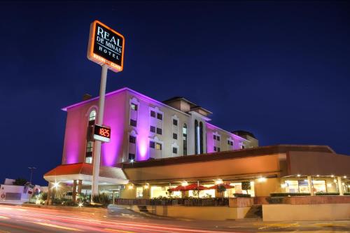 a building with a sign in front of it at night at Imperio de Angeles Executive León Poliforum in León